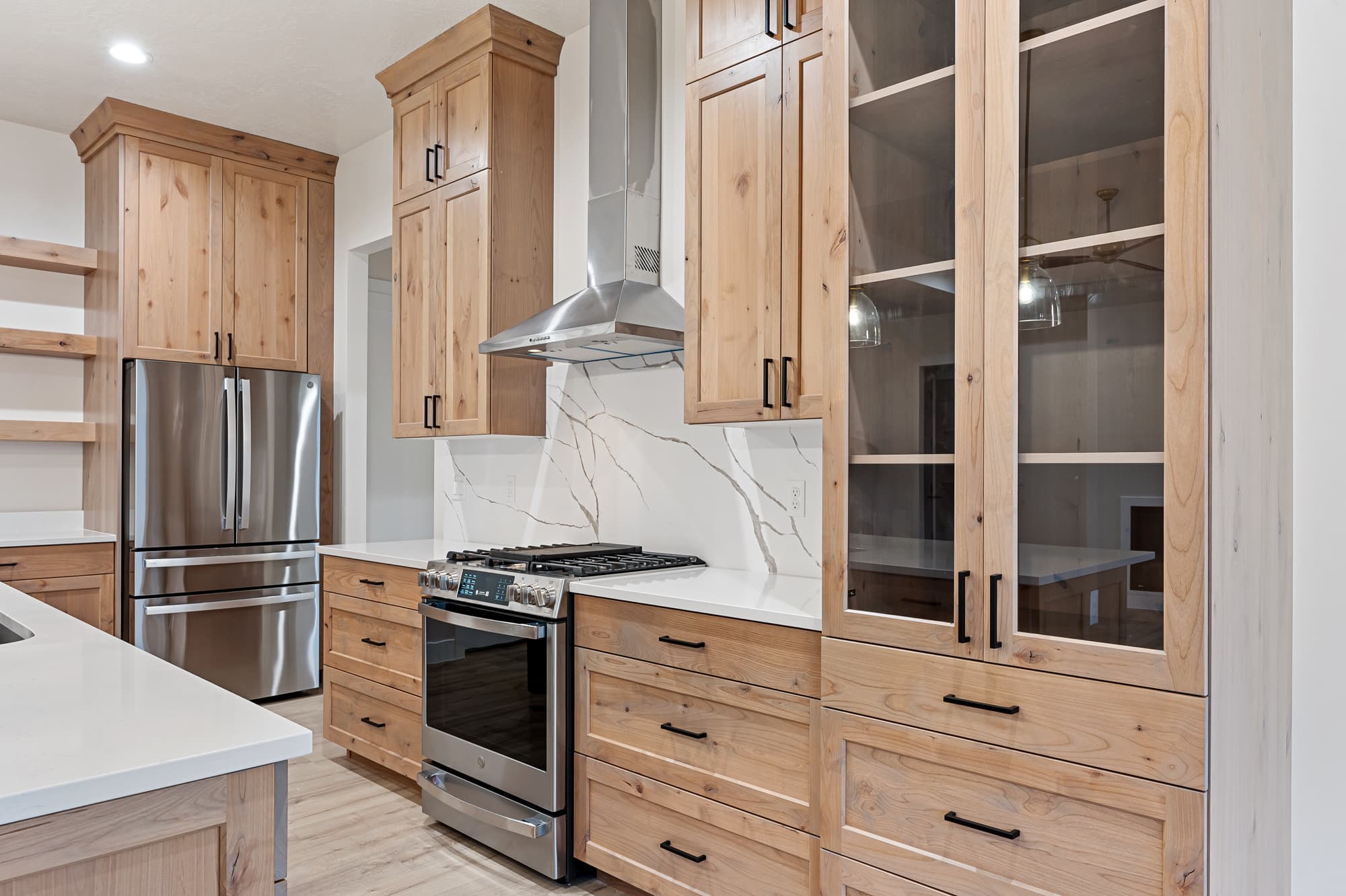 Range wall with custom hood and glass-front uppers