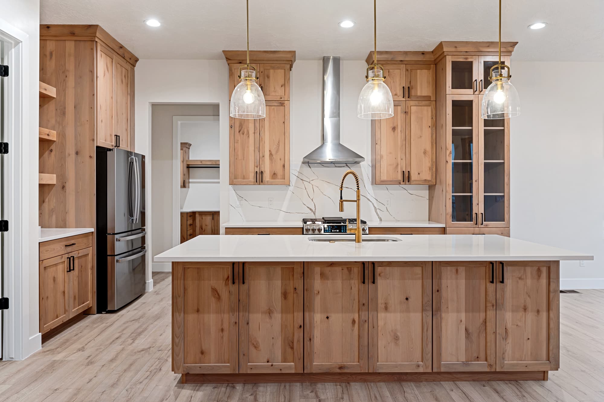 Kitchen with knotty alder cabinetry and quartz island
