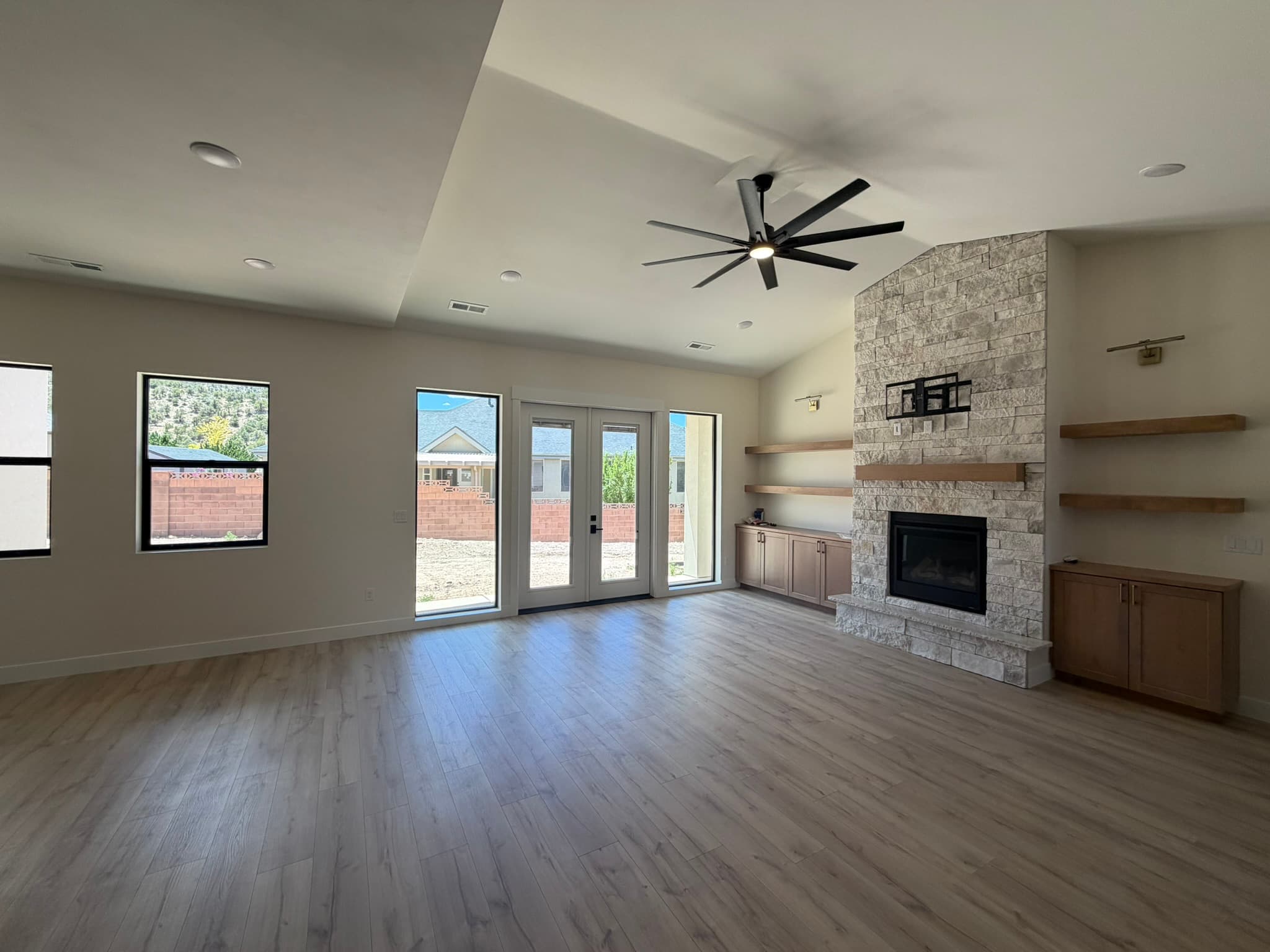 Great room with stone fireplace and picture windows